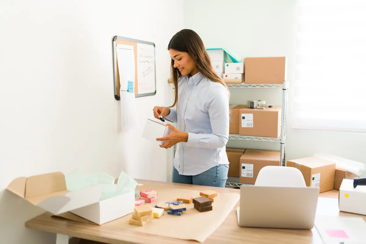 Shop-Inhaberin bereitet Pakete für Kundenbestellungen vor – kleiner Onlineshop im Alltag