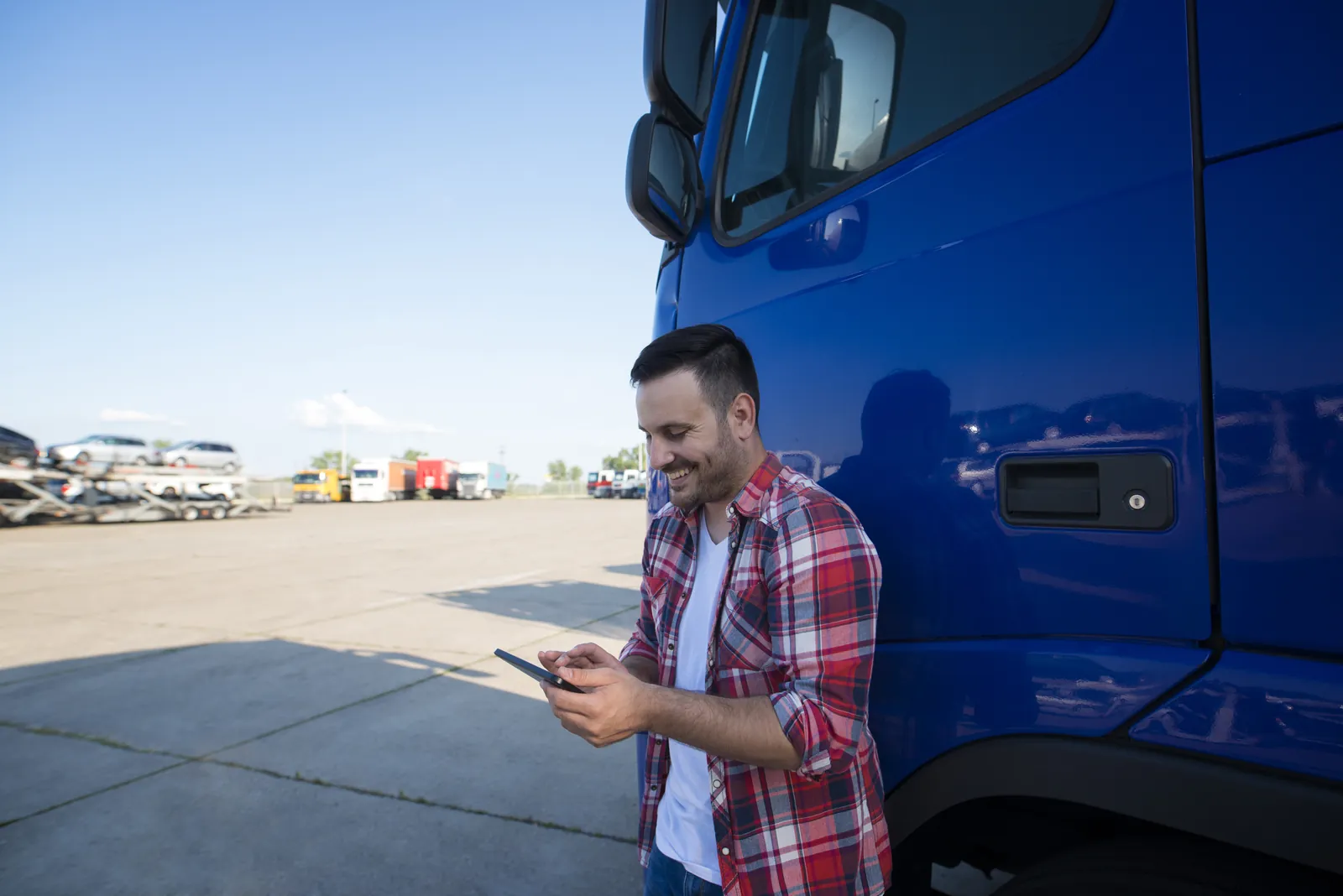 Lkw-Fahrer prüft Tour und Auftrag auf dem Tablet neben seinem Lkw – Transport & Logistik