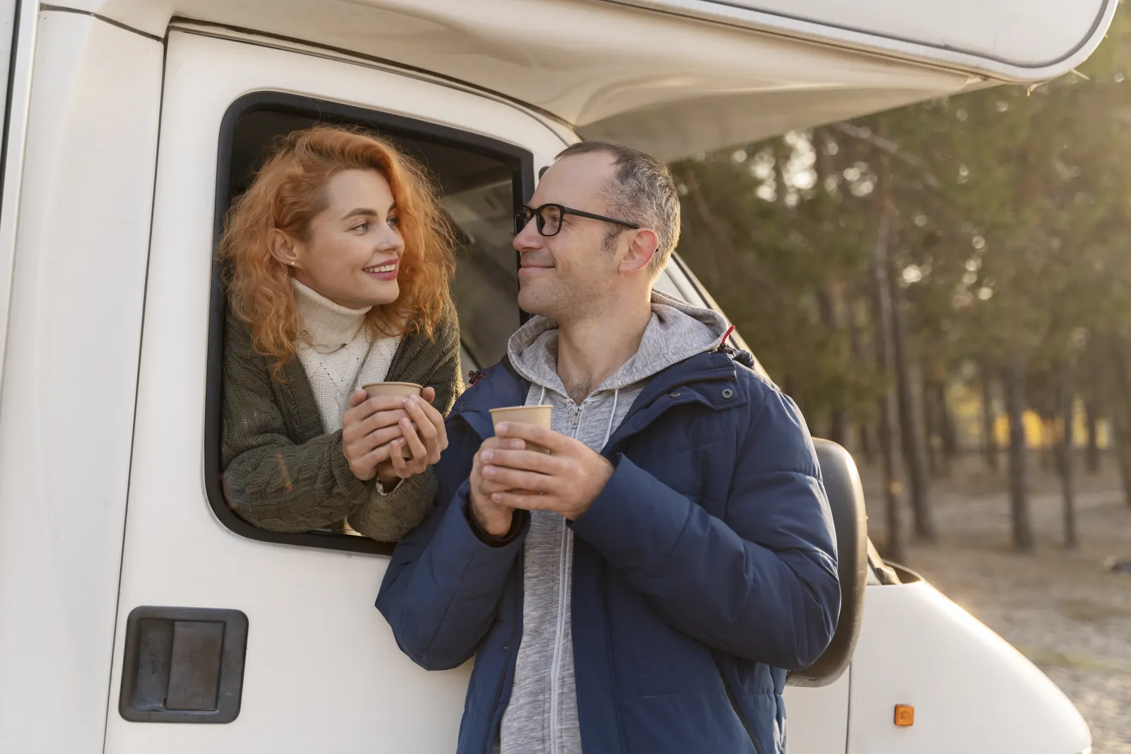 Wohnmobil Vermietung Software: Glückliches Paar am Wohnmobil vor der Reise im Wald – Armiflow für Wohnmobilvermietung